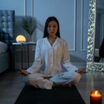 Person meditating in serene bedroom setting.